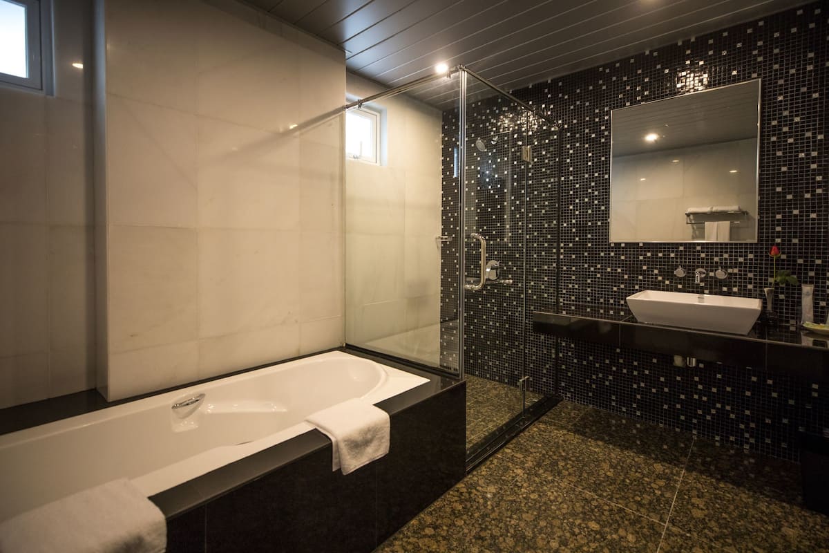 suite, 1 king bed, bathtub | bathroom | shower, free toiletries, hair dryer, slippers