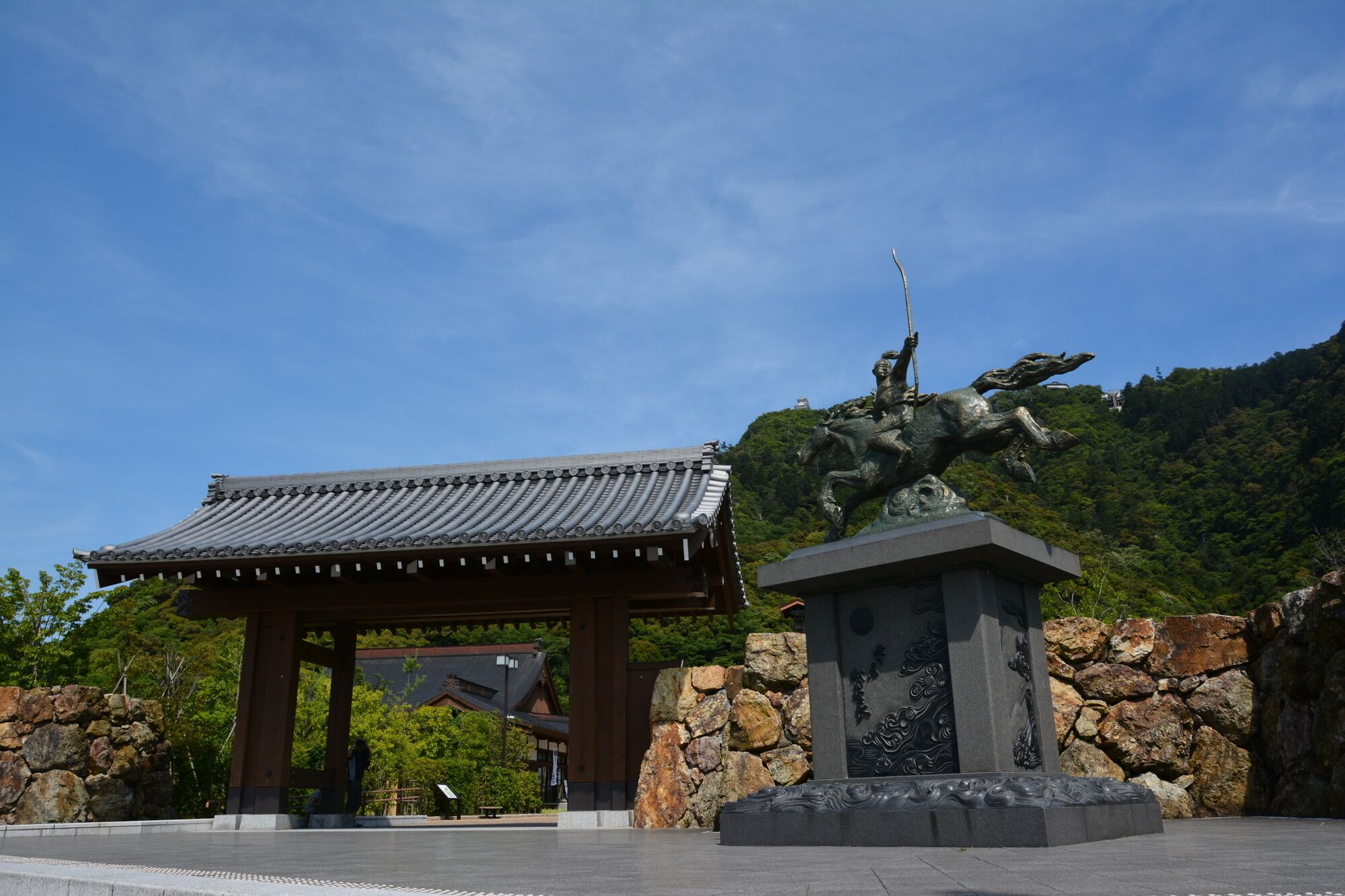 A traditional Japanese building with a tiled roof and a stone wall.