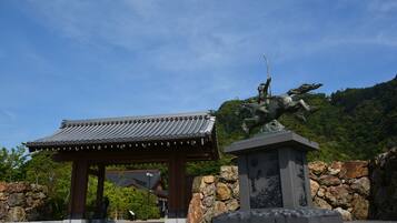 A traditional Japanese building with a tiled roof and a stone wall.