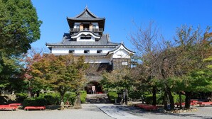 A traditional Japanese castle with a prominent tower, surrounded by trees and a gravel path. - Hotel Asia - Adults Only (Gifu)