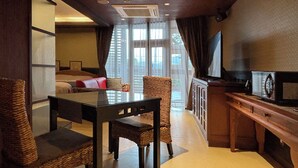A hotel room with a dining area, a sofa, a television, and a window with curtains. - Hotel Asia - Adults Only (Gifu)