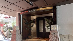 A hotel entrance with a sign reading "Hotel Asia The Essence of Resorts," a stone facade, and potted plants. - Hotel Asia - Adults Only (Gifu)
