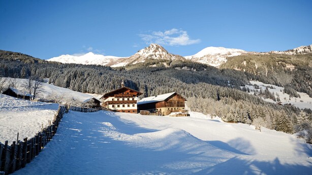 A snow-covered mountain landscape with wooden buildings and a wooden fence. - Apartment Talblick - Biohof Maurachgut (Bad Hofgastein)