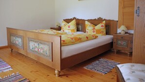 Ein Schlafzimmer mit einem hölzernen Bett, einem Nachttisch, einer Lampe und einem Gemälde an der Wand.