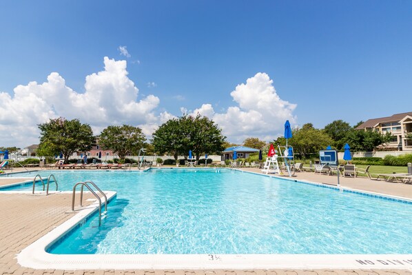 Relax by the pool surrounded by lounge chairs and umbrellas.