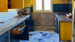 Una cucina con pareti gialle, una finestra e un pavimento in marmo.