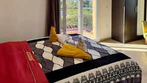 Una camera da letto con un letto, un armadio e vista sul verde dalla finestra.