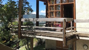 Una cabaña de madera con balcón que da a un paisaje montañoso.