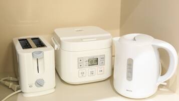 A kitchen with a toaster, a rice cooker, and a kettle.