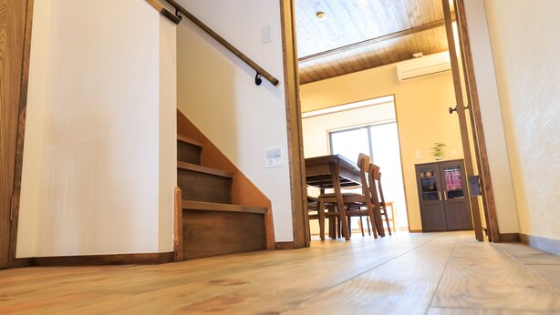 A wooden staircase leading to a dining area with a table and chairs.