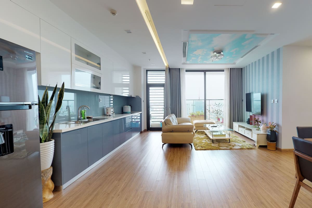 A modern apartment with a kitchen, dining area, and living room.