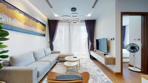Een moderne woonkamer met een bank, salontafel en televisie.