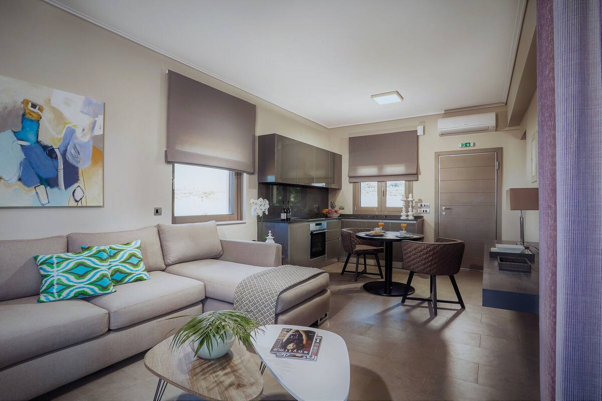 Ein modernes Wohnzimmer mit Sofa, Couchtisch und Essbereich mit Stuhl und Tisch.