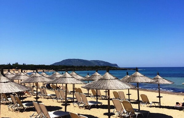 靠近海滩、白沙、沙滩椅、海滩遮阳伞