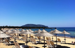 Una playa cerca, arena blanca, sillas reclinables de playa, sombrillas