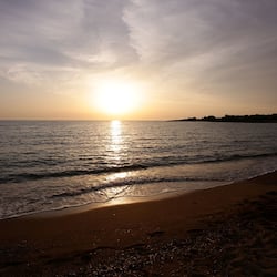 Una spiaggia nelle vicinanze, sabbia bianca, lettini da mare, ombrelloni