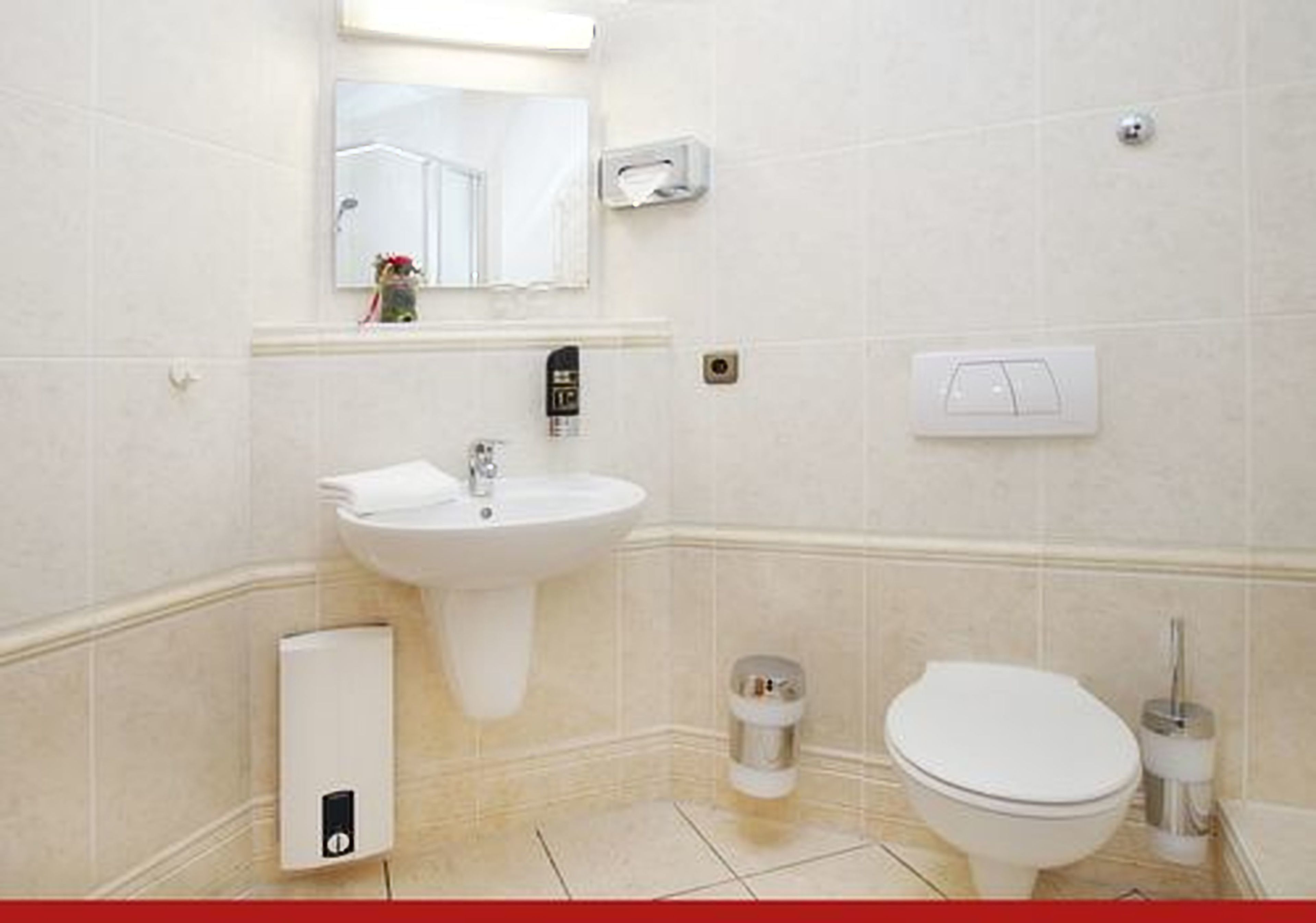 Une salle de bain avec un lavabo, des toilettes et un miroir.