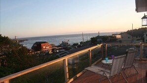 Een balkon met uitzicht op de oceaan en een weg.