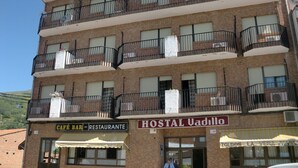 Un edificio de varios pisos con balcones, un bar-cafetería y un restaurante en la planta baja.