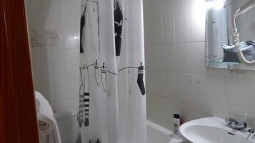 A bathroom with a shower curtain featuring black line drawings, a white sink, and a mirror above it.
