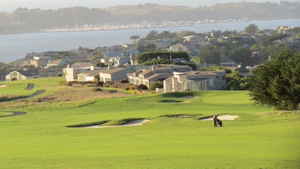 A golf course with a view of a marina and residential buildings in the background. - Spacious 5-bedrm home:Ocean Views,hot tub,BBQ,pool & ping pong tables, fast wifi (Bodega Bay)