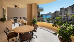 A balcony with a round table and chairs, a ceiling fan, and potted plants. - Everything you need! Ocean views from your balcony! (Cabo San Lucas)
