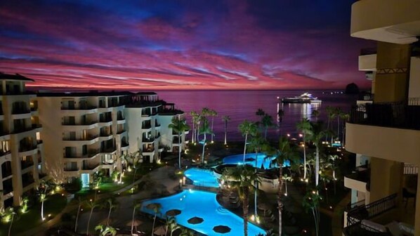 A resort with multiple buildings, a swimming pool, and a view of the ocean at sunset. - Pools * Hot Tubs * Swim-Up Bar * Spa * Pickleball * Medano Beach! (Cabo San Lucas)