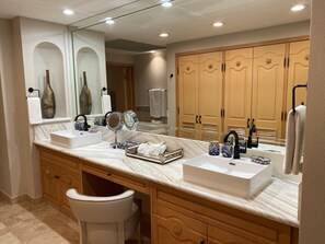 A bathroom with two sinks, a vanity, a mirror, and wooden cabinets. - Pools * Hot Tubs * Swim-Up Bar * Spa * Pickleball * Medano Beach! (Cabo San Lucas)