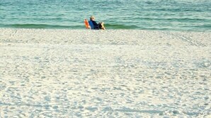 A person sitting on a beach with the ocean in the background. - Prime October Dates Are Open! Perfect Time For a Beach Trip! (Orange Beach)
