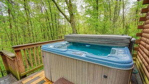 A hot tub on a wooden deck surrounded by a forest. - Blue Rose Cabins - Pine Ridge Cabin (Logan)