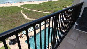 A balcony with a view of a beach and a swimming pool. - Oceanside Zen Escape - Condo 503: 2BR, 2BA retreat in South Padre Island. (South Padre Island)