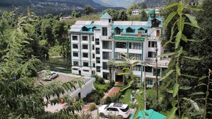 A hotel with a green roof, multiple floors, and a garden area. - Royal Park Resort (Manali)