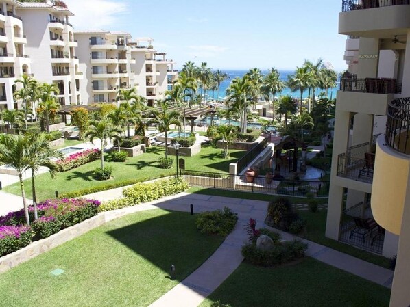 A resort with multiple buildings, a pool area, and palm trees.