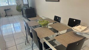 A dining area with a glass table, black chairs, and a wicker basket. - Beautiful vacation home - just 2-Minute Walk to World-Famous Daytona Beach (Daytona Beach)