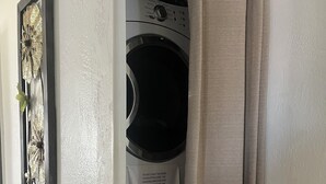 A laundry area with stacked washing machines and a curtain. - Beautiful vacation home - just 2-Minute Walk to World-Famous Daytona Beach (Daytona Beach)