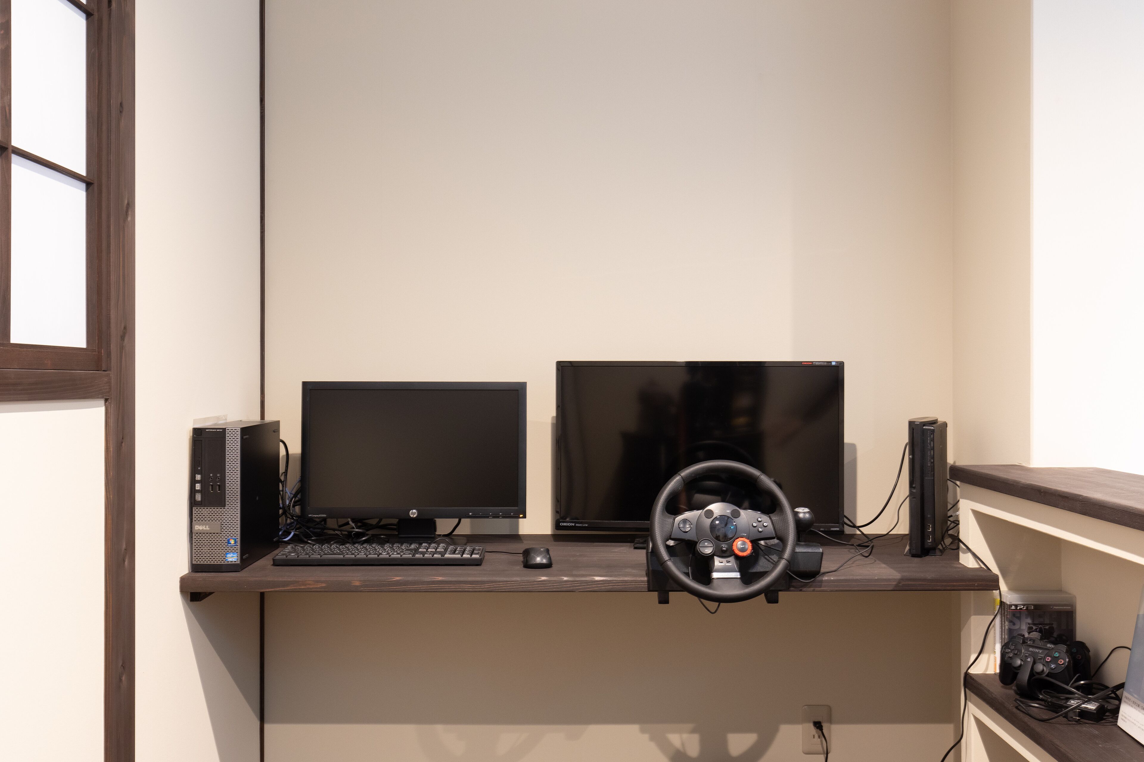 Un bureau d’ordinateur équipé de deux écrans, d’un clavier, d’une souris et d’un volant de jeu.
