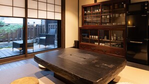 Una habitació tradicional japonesa amb sòls de tatami, una taula baixa i un armari de paret amb portes de vidre.