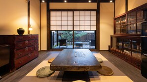 Habitació japonesa tradicional amb fons de tatami, una taula de fusta baixa, portes corredisses i un armari de paret.