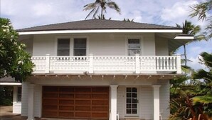 A two-story house with a balcony, a garage, and a driveway.