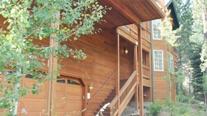 A wooden cabin with a covered porch, a staircase, and a garage. - Beautiful Tahoe Chalet, 5 BR, 3 Bath, Hot Tub, Jacuzzi Bath, 3 Spacious Decks (South Lake Tahoe)