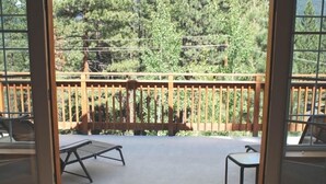 A balcony with a wooden railing, a metal table, and a chair. - Beautiful Tahoe Chalet, 5 BR, 3 Bath, Hot Tub, Jacuzzi Bath, 3 Spacious Decks (South Lake Tahoe)