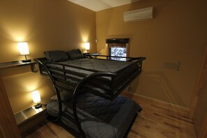 A bunk bed room with two bedside tables, each with a lamp, and an air conditioning unit on the wall. - Quiet Modern Luxury Home w/  Memory Foam Beds, A/C, FAST WiFi and Full Kitchen (Bridgewater)