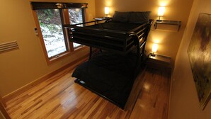 A compact room with a bunk bed, a window with a view of trees, and two bedside lamps. - Quiet Modern Luxury Home w/  Memory Foam Beds, A/C, FAST WiFi and Full Kitchen (Bridgewater)