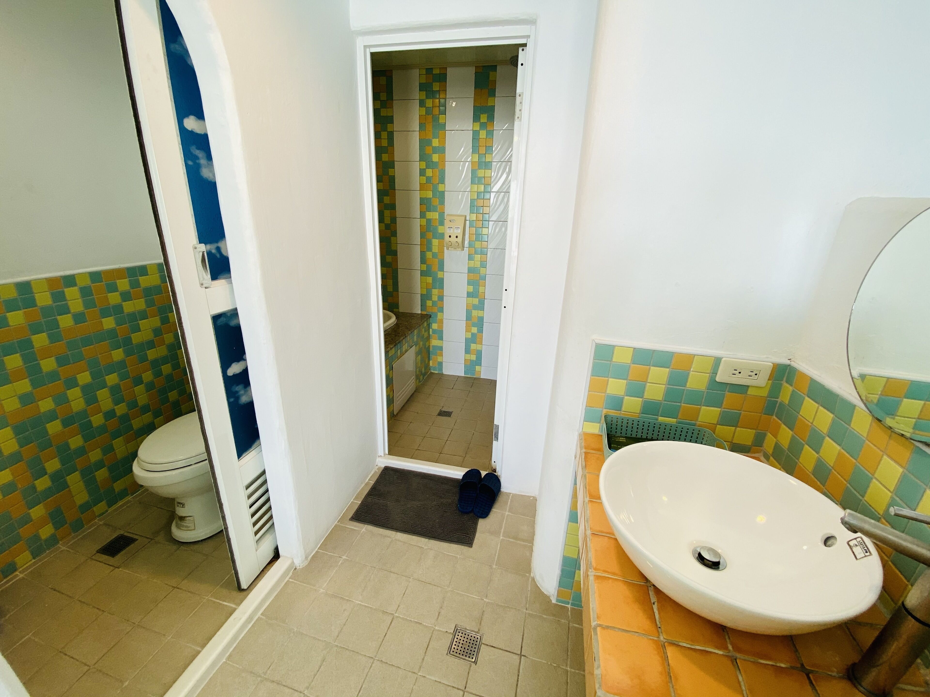 A bathroom with a toilet, sink, and shower area.