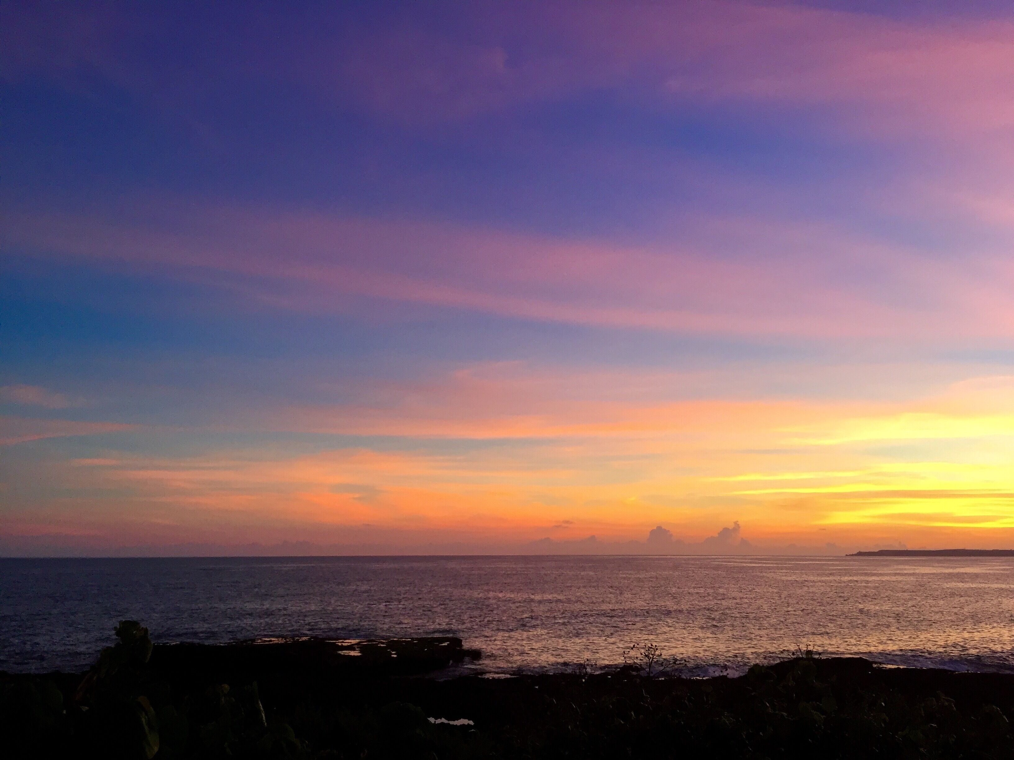 Una vista del atardecer costero con una costa rocosa.