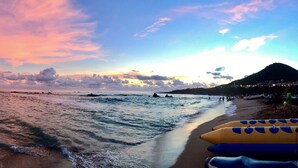 A beach with a sunset, waves, and beachgoers. - Seya Inn (Hengchun)