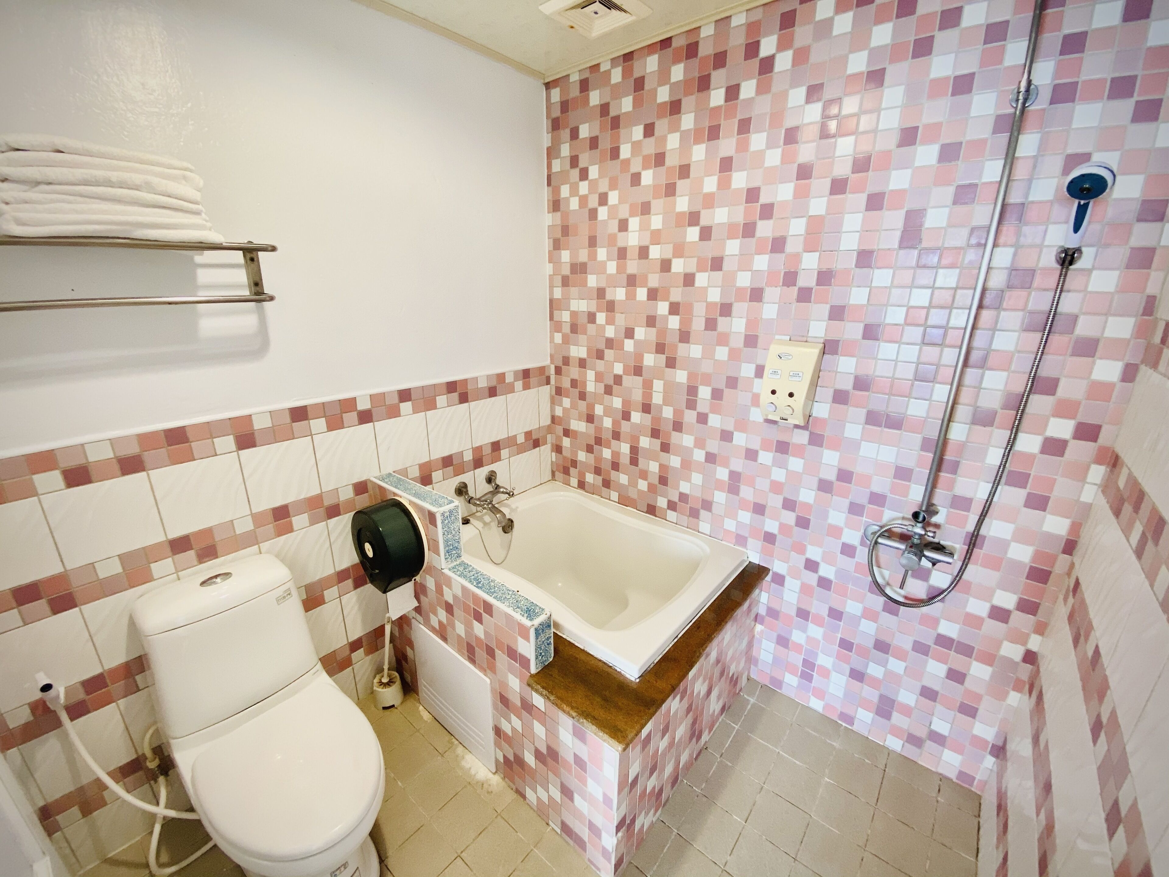 A bathroom with a toilet, a sink, a shower, and a towel rack.
