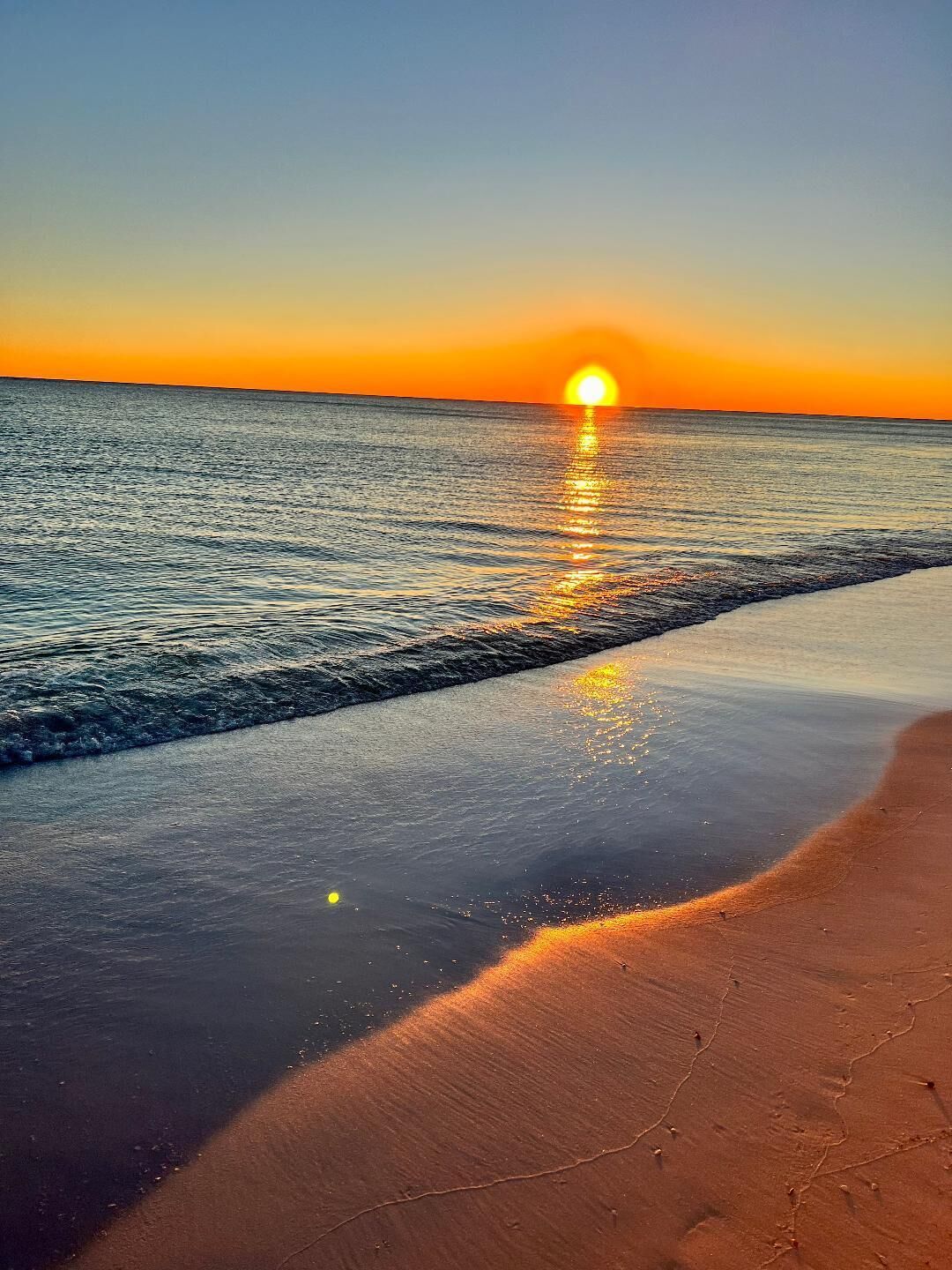 Una spiaggia con un tramonto sull'oceano.