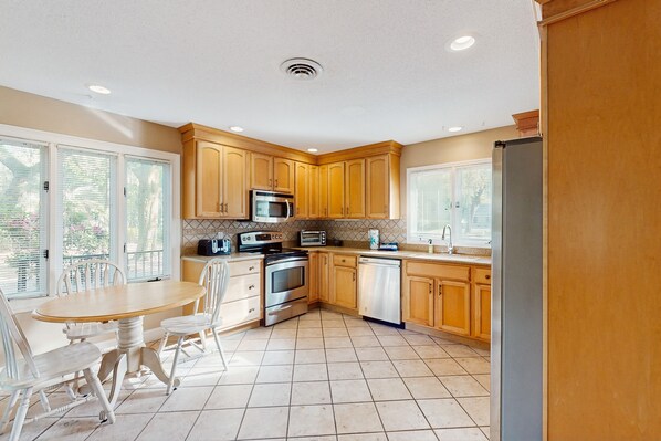 Enjoy cooking in this well-equipped kitchen with a central island, stainless steel appliances, and ample natural light.