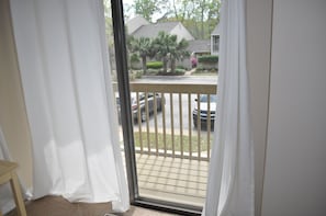 Enjoy the view from this balcony overlooking a quiet residential street lined with homes and trees.